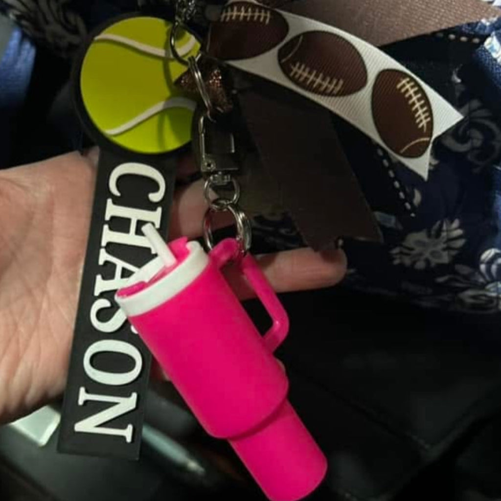Custom tennis ball bag tag attached to a backback