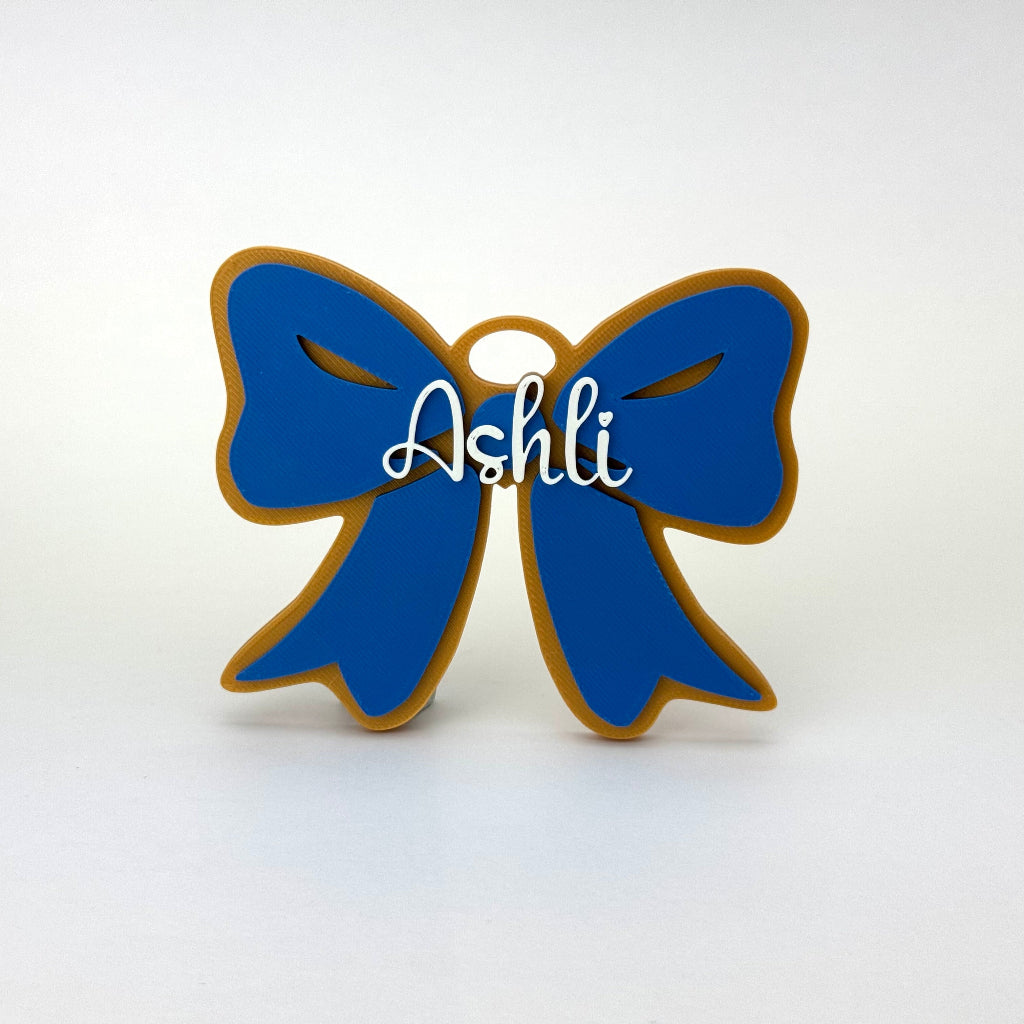 Personalized spirit bow bag tag for Cass in blue, gold, and white