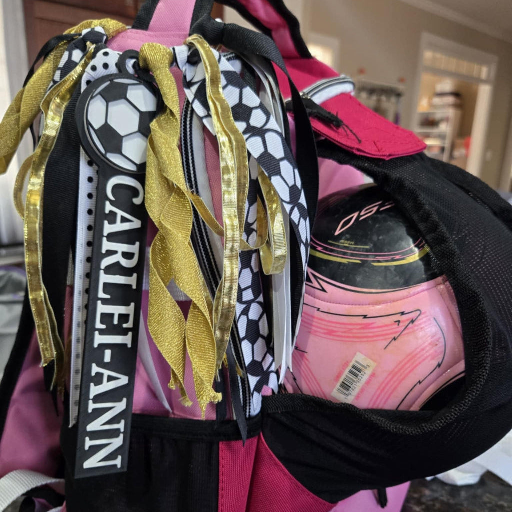 Customer photo of a soccer bag tag attached to a backpack with ribbons