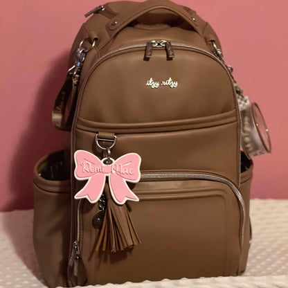 pink bow bag tag attached to diaper bag