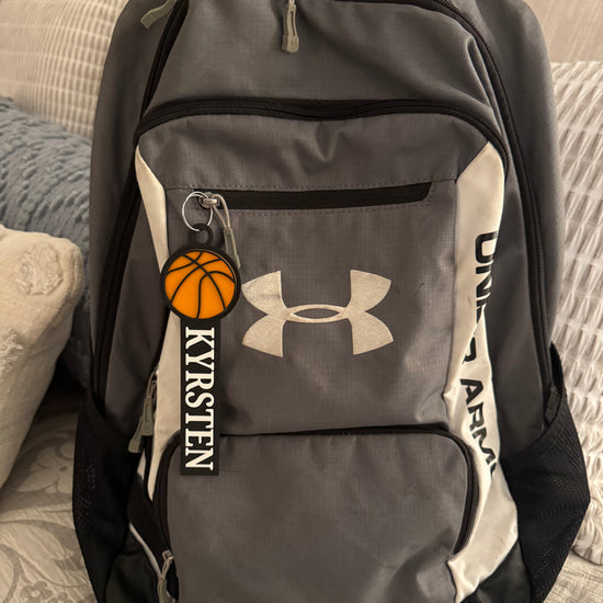 Example of the custom basketball bag tag with a girls name attached to a backpack